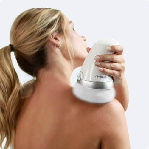 Mujer usando Vibro Sculpt en la espalda para masaje relajante.